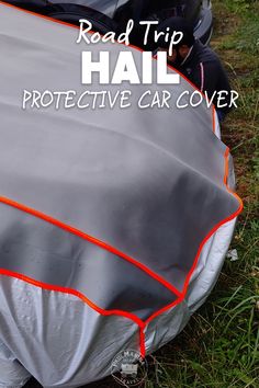 a car covered in a gray and orange cover with the words road trip hail protective over it