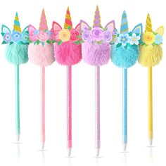 five unicorn pencils lined up in different colors with flowers and feathers on the top