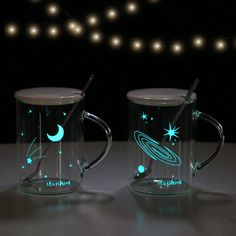 two glass mugs with glow in the dark designs