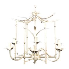 a white chandelier with six candles hanging from it's center and four arms