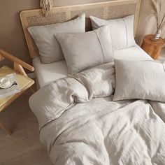 an unmade bed with white linens and pillows