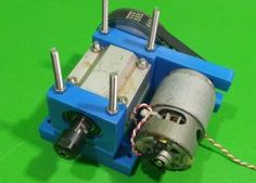 an electric motor on a green surface with wires and screws attached to the rotor