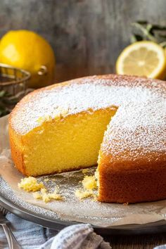 a lemon cake on a plate with one slice cut out