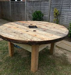 a wooden table sitting in the middle of a yard