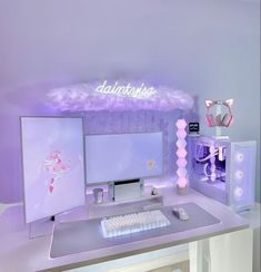 there is a desk with a computer and keyboard on it in the room that has purple lighting