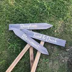 three wooden directional signs sitting in the grass