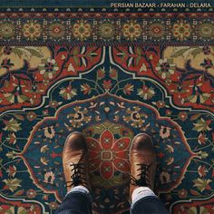 the feet of a person standing in front of a rug