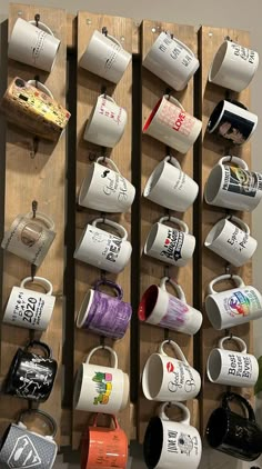 coffee mugs are hanging on the wall with hooks