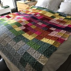 a crocheted blanket sitting on top of a bed