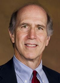 a man in a suit and tie smiling at the camera