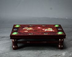 a wooden table topped with lots of different colored glass knobs and decorations on it