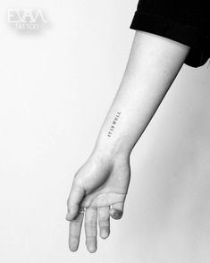 a woman's hand with the word love tattooed on her left wrist, in black and white