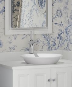 a white sink sitting under a bathroom mirror next to a wall mounted faucet