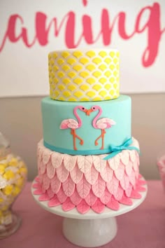 three tiered cake with flamingos on top and pineapples in the background