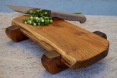 a wooden cutting board with chopped green onions on it and a knife resting on top