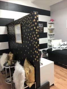 a black and white room with gold polka dots on the walls, furniture and decor