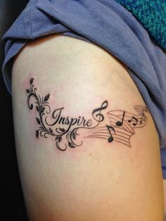 a woman's thigh with music notes and the word inspire written on her side