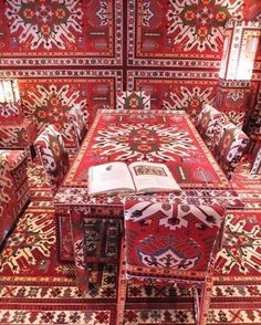 a room filled with lots of red and white rugs on top of each other