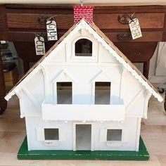 a white doll house sitting on top of a wooden table