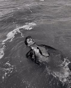 black and white photograph of a man swimming in the ocean with his head above water