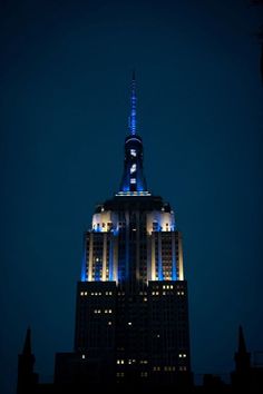 the empire building lit up in blue and white