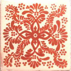 a red and white tile with an intricate design