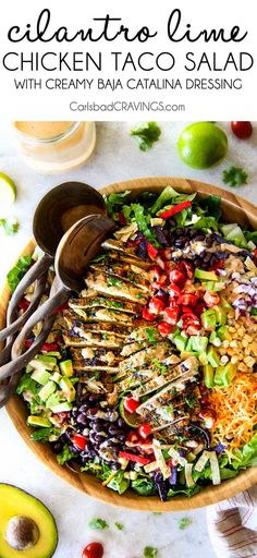 chicken taco salad in a wooden bowl with cilantro limes on the side