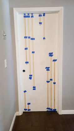 a white door with blue tape on it and some wooden sticks sticking out of it