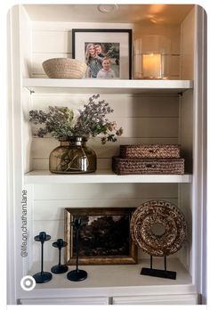 the shelves are filled with vases, pictures and other decorative items on top of them