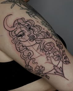 a woman's arm with a black and white tattoo design on her left shoulder