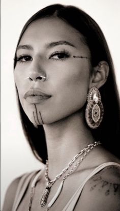 a black and white photo of a woman with piercings on her nose