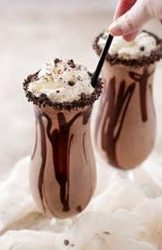 two glasses filled with chocolate and whipped cream