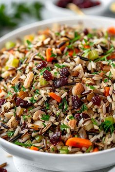 a white bowl filled with wild rice and cranberries on top of a table