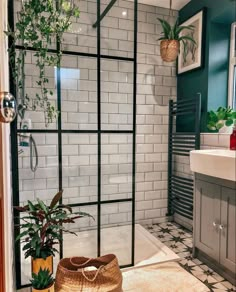 a bathroom with tiled walls and flooring next to a bathtub filled with plants