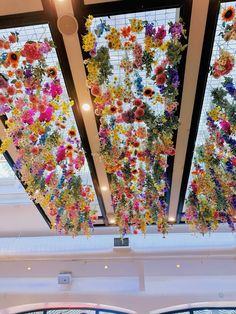 colorful flowers are hanging from the ceiling in a building