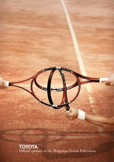 a person holding a tennis racquet on top of a tennis court with the words toyota written on it