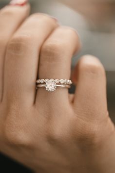 a woman's hand with a diamond ring on it