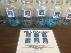 there are many jars with pictures in them on the table and one has a sign that says pie a teacher