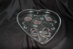 a heart shaped glass dish with flowers on it