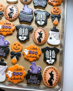 decorated cookies in the shape of t - shirts and skeletons are on display for halloween