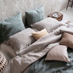 an unmade bed with many pillows on it