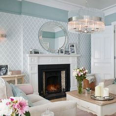 a living room filled with furniture and a fire place in front of a mirror on the wall