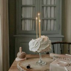 a cake sitting on top of a table with two candles in the middle of it