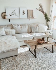 a living room filled with lots of white furniture and decor on top of a rug