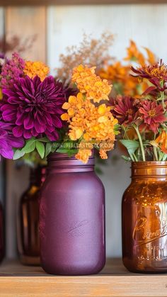 three mason jars with flowers in them sitting on a shelf next to other vases