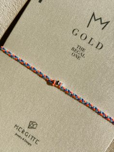 an orange and blue rope is on top of a book that reads, i m gold