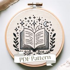 an embroidered book with the words pdf pattern on it and a ribbon around it