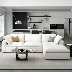 a living room filled with furniture and a glass table in front of a kitchen area