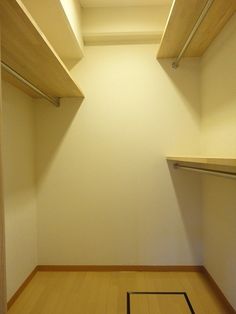 an empty walk in closet with wooden shelves