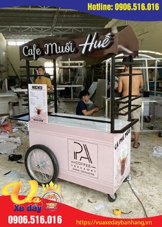 an ice cream cart with people working behind it